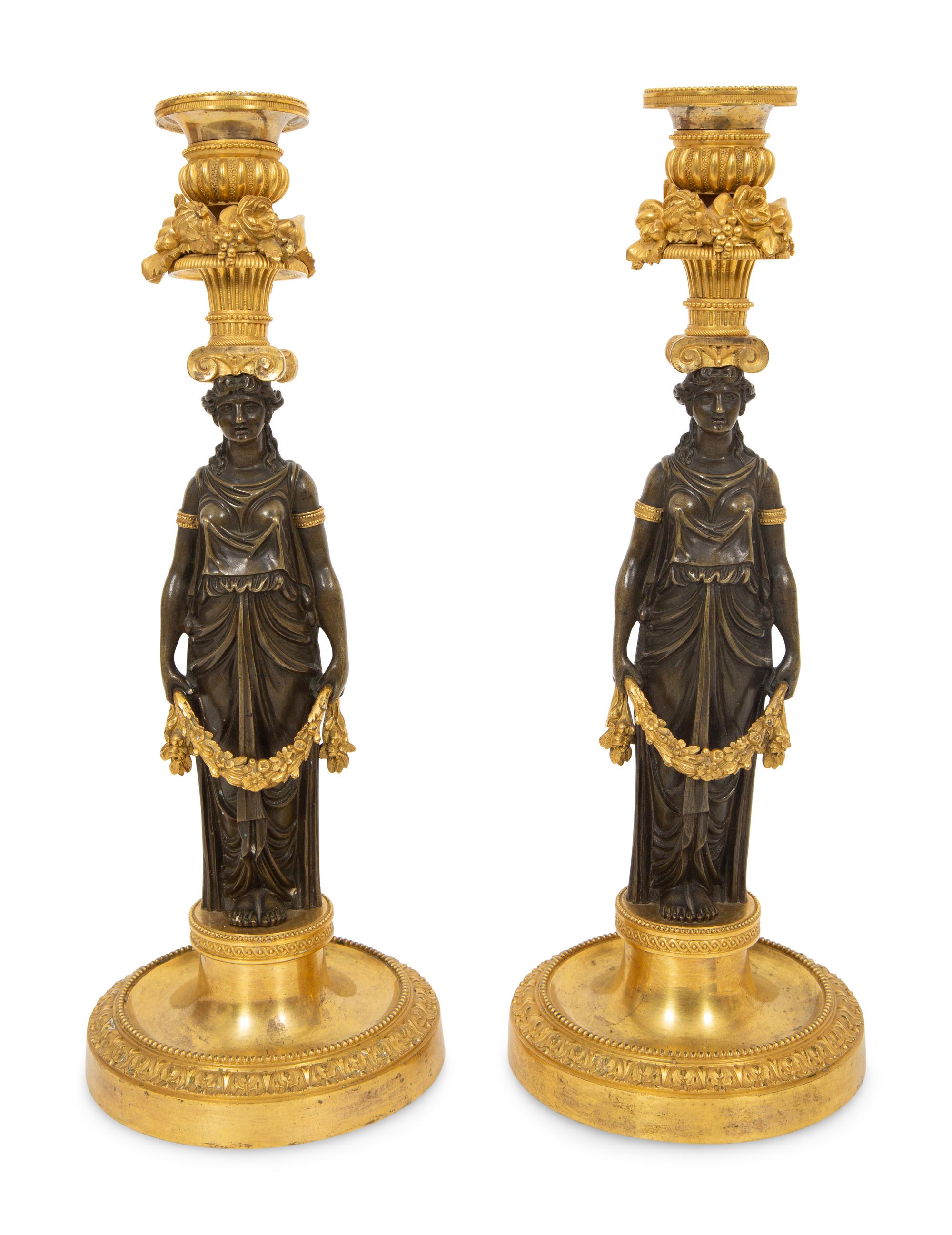 A Pair of French Gilt and Patinated Bronze Figural Candlesticks