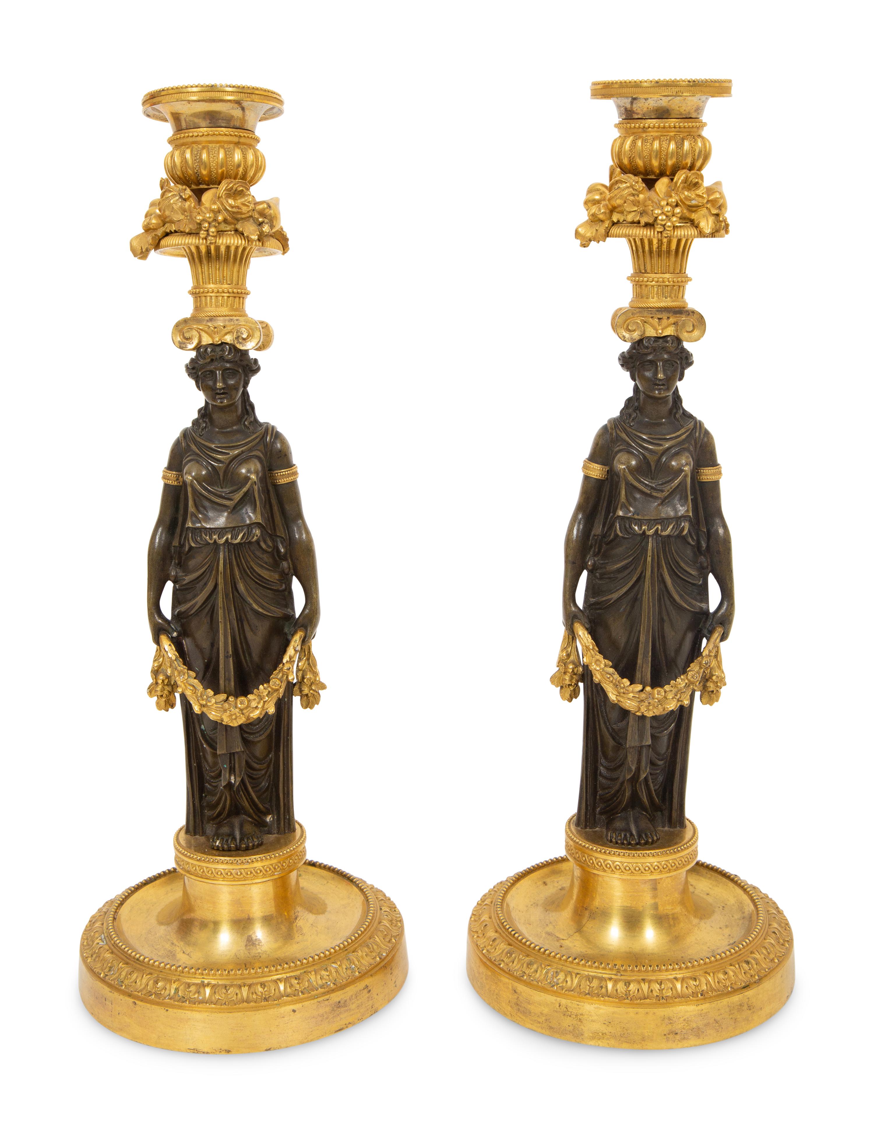 A Pair of French Gilt and Patinated Bronze Figural Candlesticks