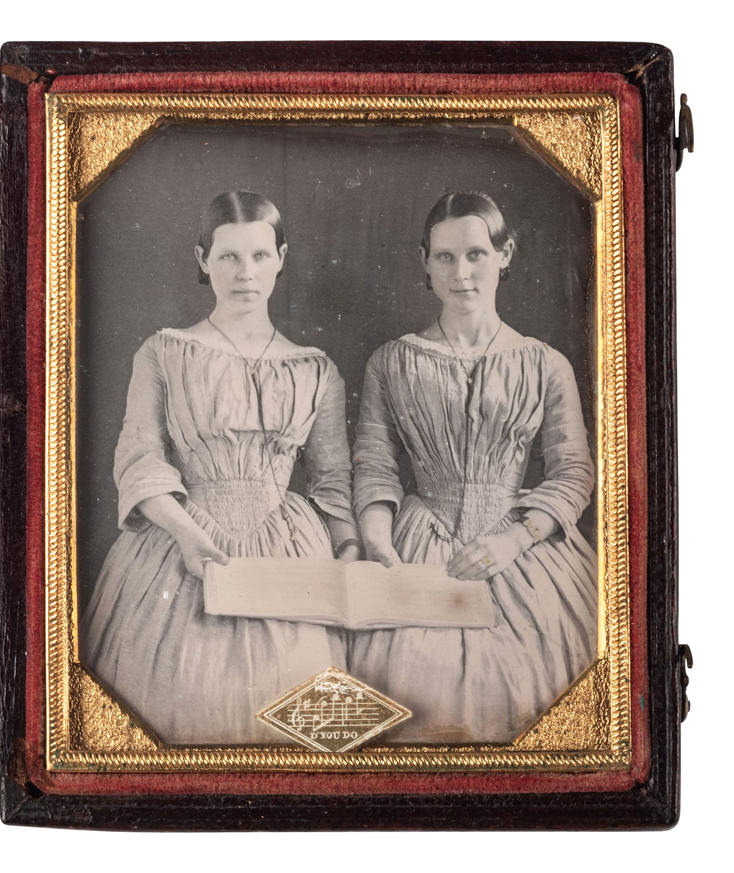 [EARLY PHOTOGRAPHY]. Sixth plate daguerreotype featuring possible twin sisters holding open a music folio.
