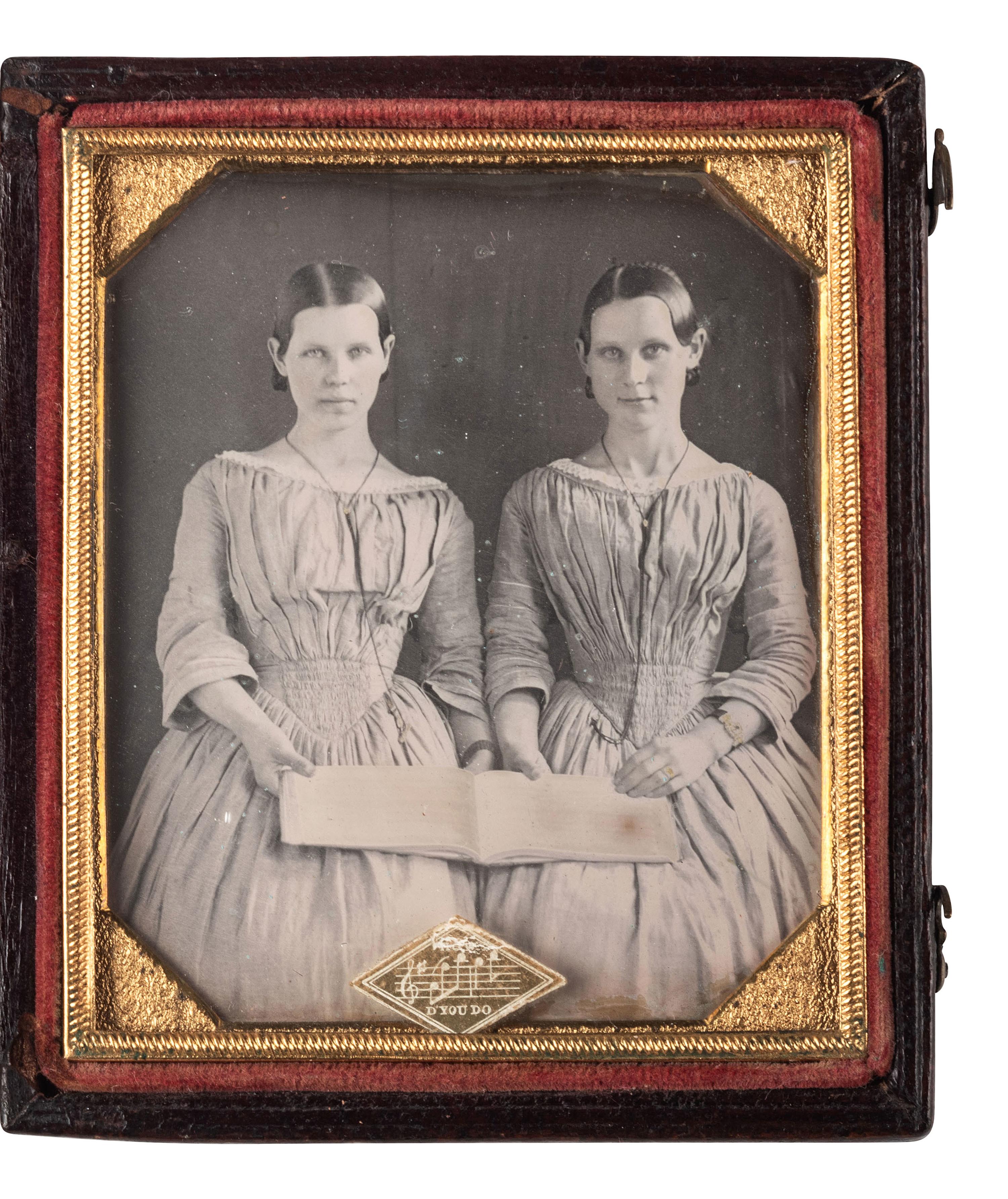 [EARLY PHOTOGRAPHY]. Sixth plate daguerreotype featuring possible twin sisters holding open a music folio.