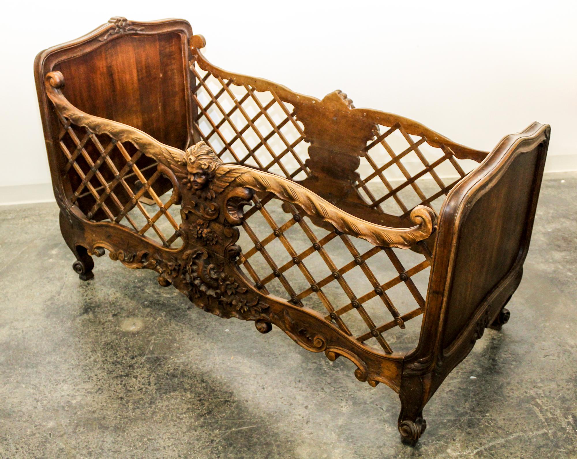 A French Carved Wood Crib Height 37 3/4 x width 60 x depth 31 1/4 inches. — 19TH CENTURY