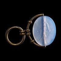 A Greek Blue Chalcedony Intaglio with a Satyr Holding a Herm — Set in a gold pendant