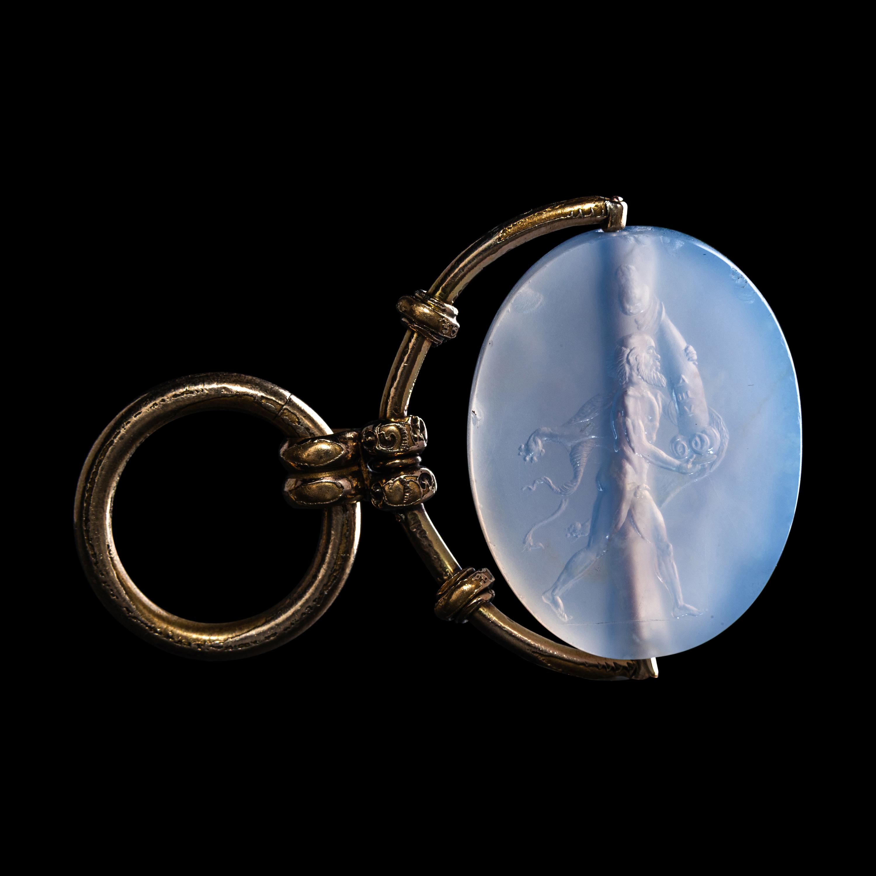 A Greek Blue Chalcedony Intaglio with a Satyr Holding a Herm — Set in a gold pendant