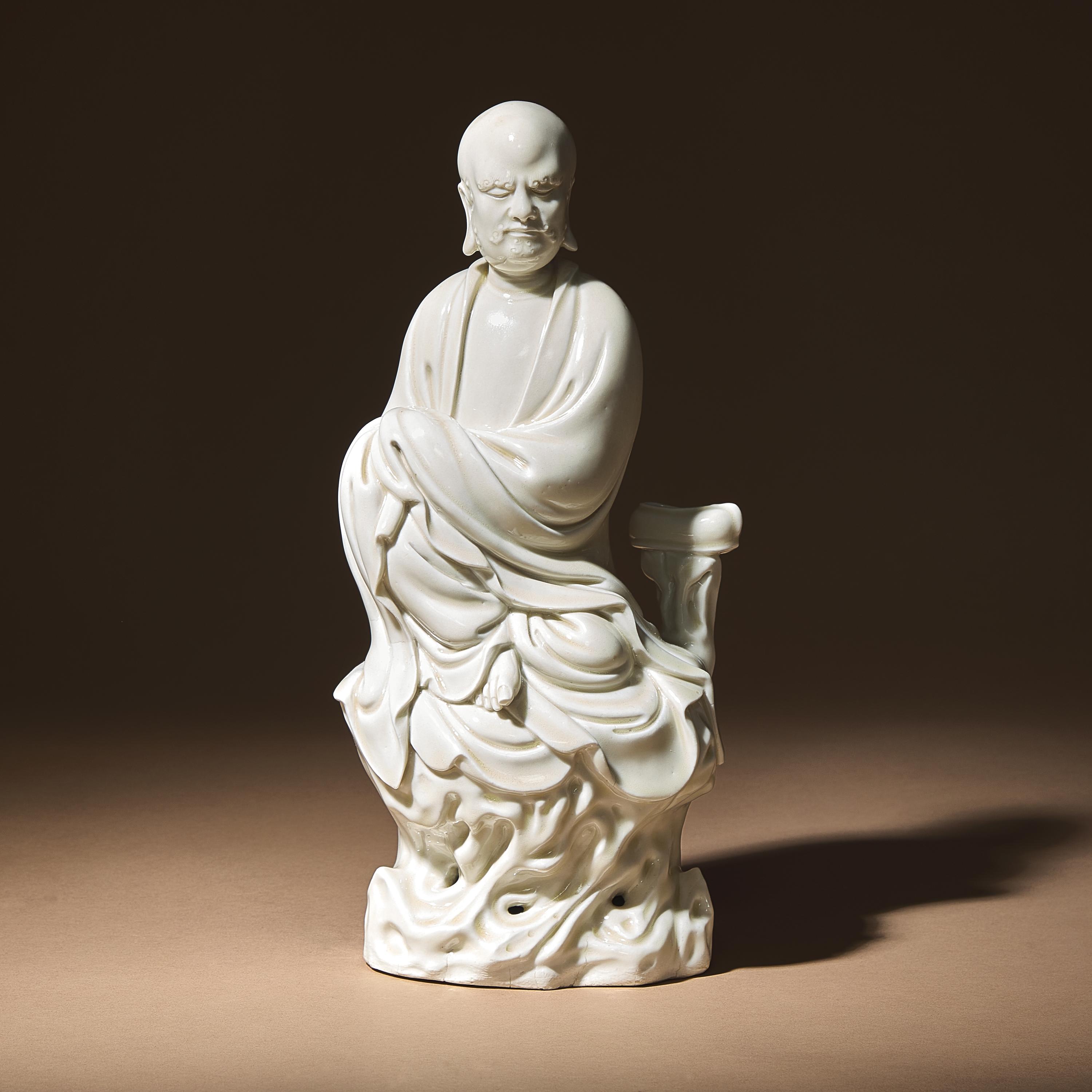 A Chinese Blanc-de-Chine Porcelain Seated Figure of Damo with 'He Chaozong' Mark, Qing Dynasty — 清 何朝宗款“隻履西歸”德化白瓷達摩坐像