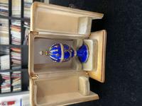 A 14 Karat Vari-Color Gold, Guilloché Enamel, Diamond, and Cabochon Jewel-Mounted Egg-Form Perfume and a Related Guilloché Enamel, 14 Karat Vari-Color Gold, Diamond, and Cabochon-Mounted Surprise Egg