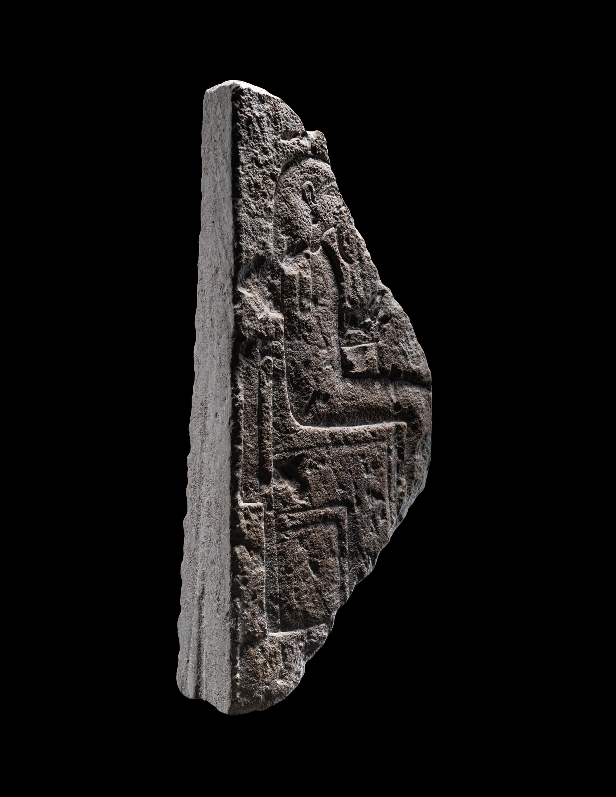 An Egyptian Limestone Stele Fragment with a Seated Pharaoh
