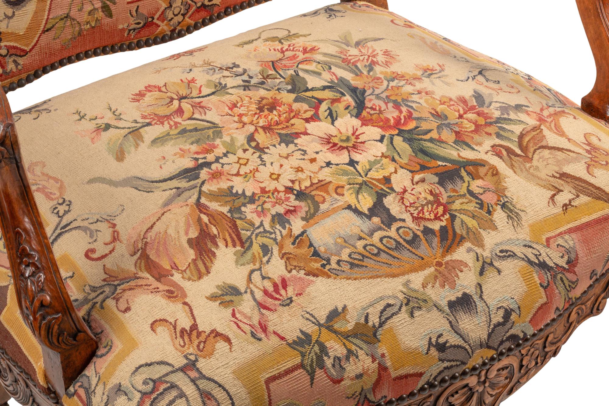 A Pair of Régence Style Carved Walnut and Tapestry-Upholstered Armchairs