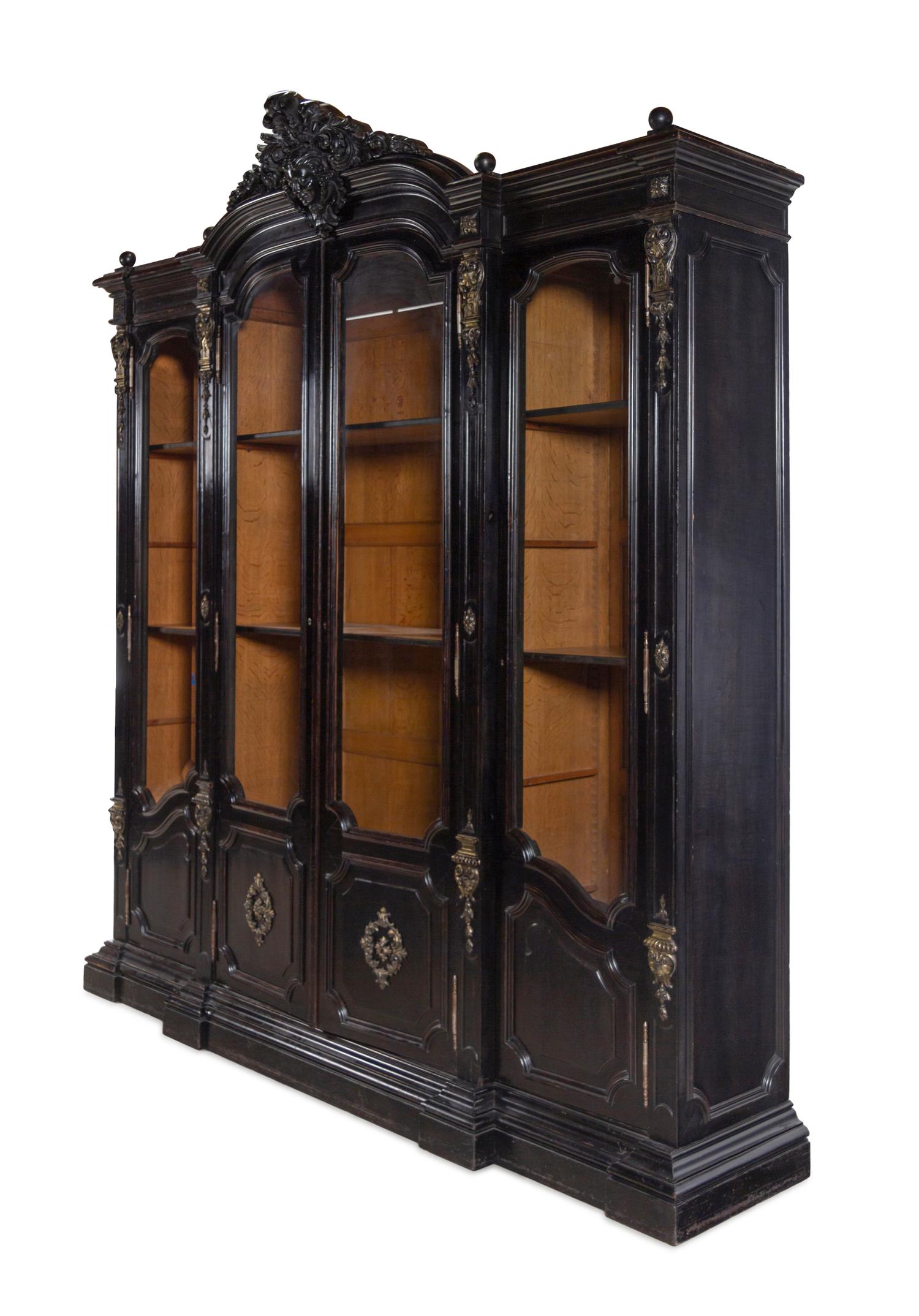 An Italian Rococo Revival Carved Ebonized Bookcase
