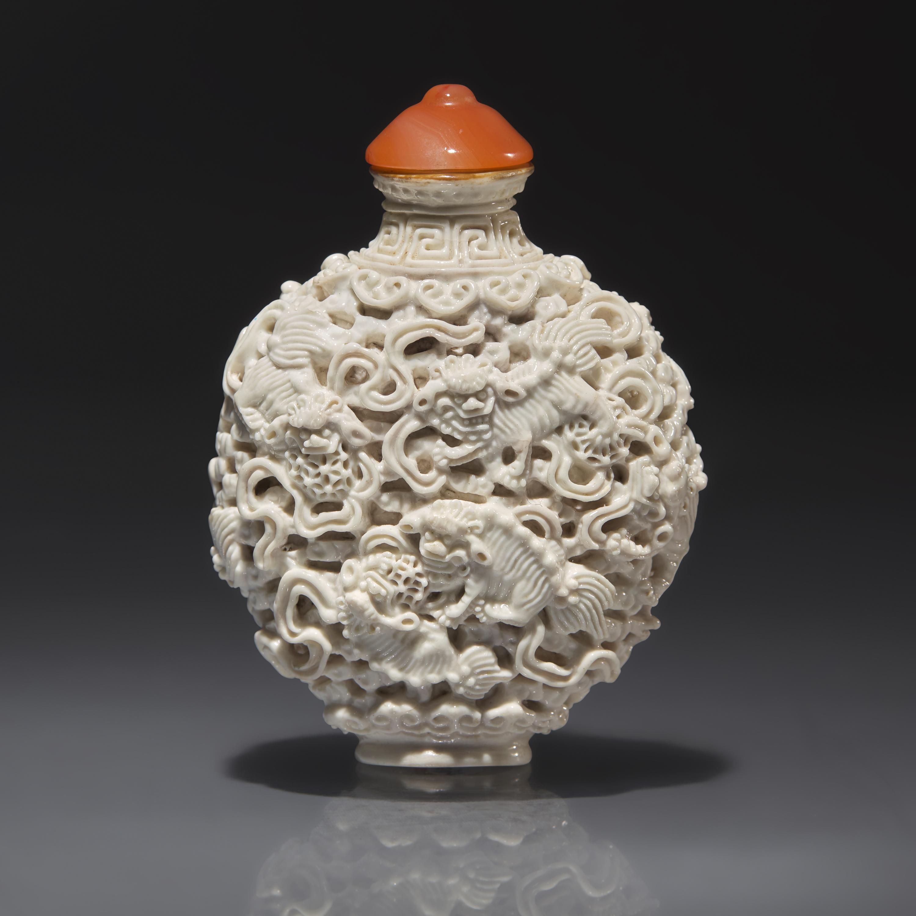 A Chinese Molded White-Glazed Porcelain "Buddhist Lions" Snuff Bottle, Qing Dynasty, Jiaqing Mark and of the Period