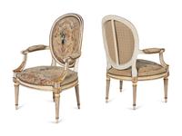 A Set of Four Louis XVI Crème-Painted and Parcel Gilt Fauteuils
