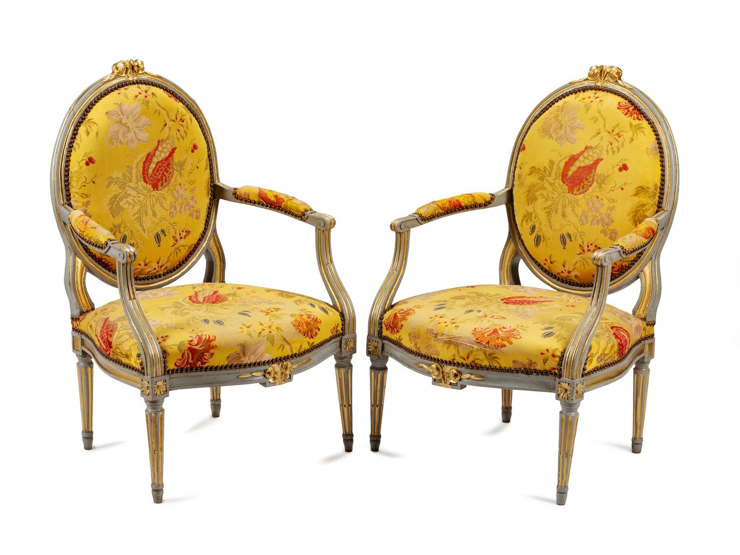 A Pair of Louis XVI Painted and Parcel Gilt Fauteuils
