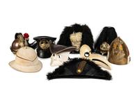 A Collection of Twenty-One Military Parade Helmets, Hats and Masks