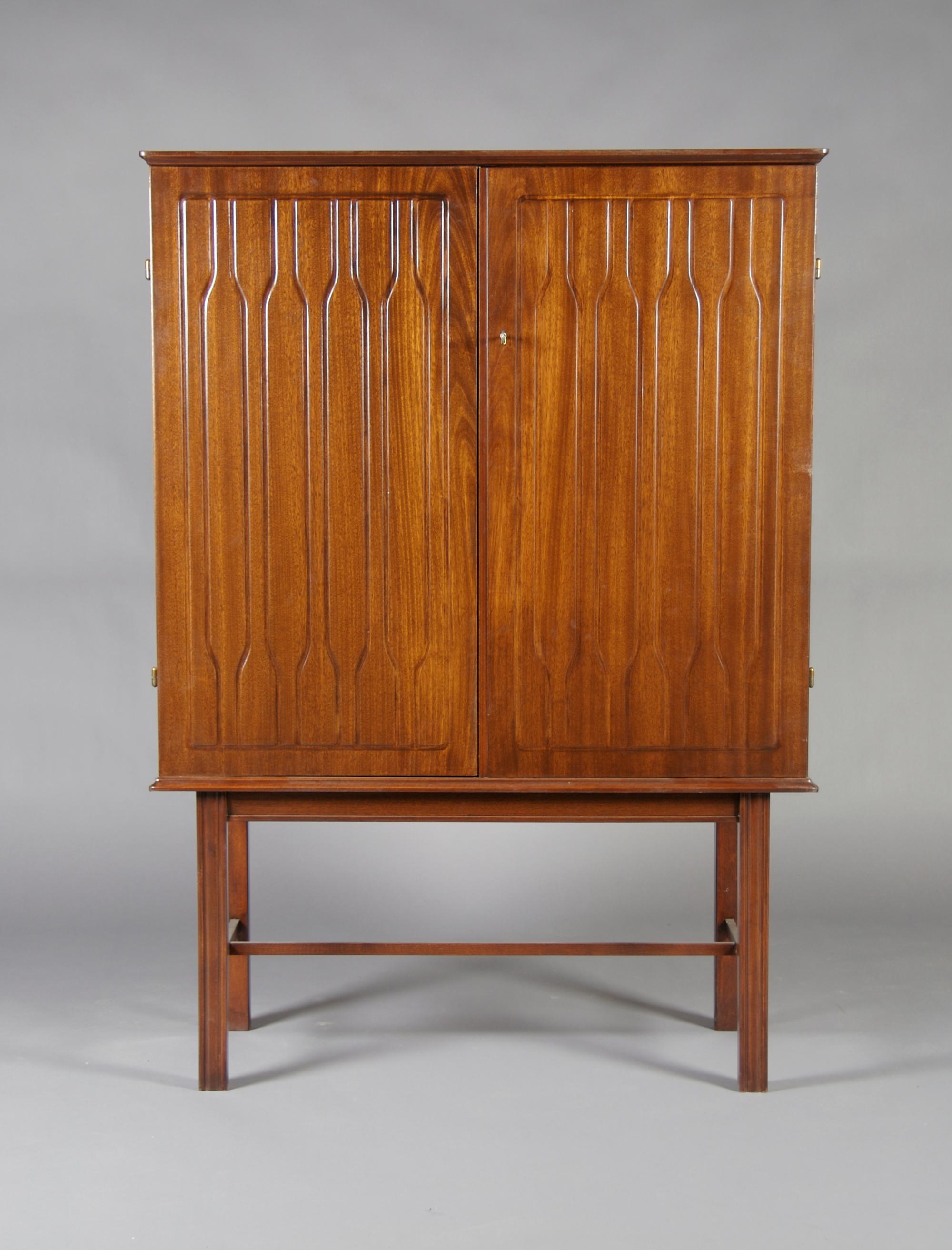 A Swedish Pressed Mahogany Cabinet on Stand, Height 56 3/4 x width 40 1/2 x depth 17 5/16 inches.