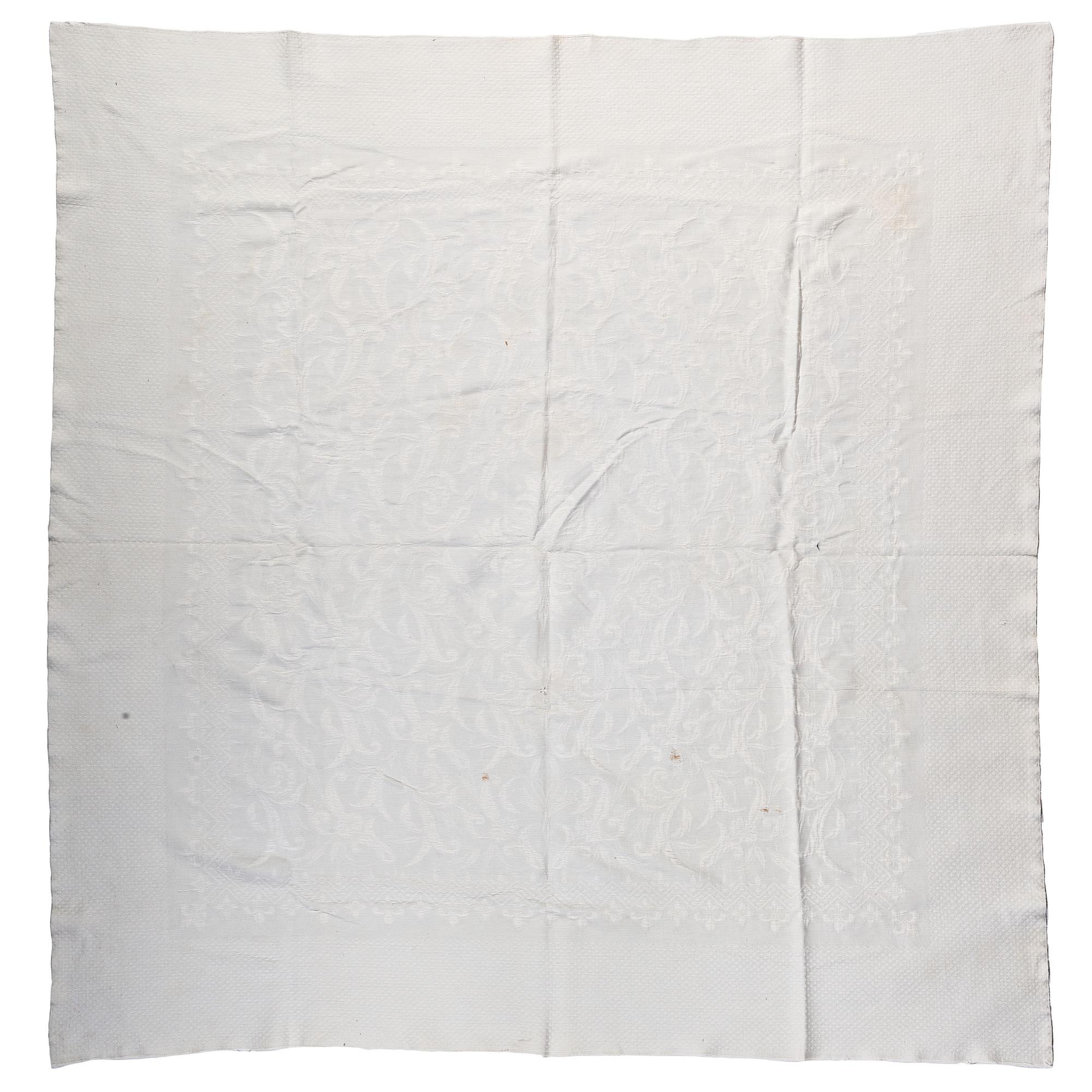 A Pieced Sunburst Quilt and a White Matelasse Coverlet