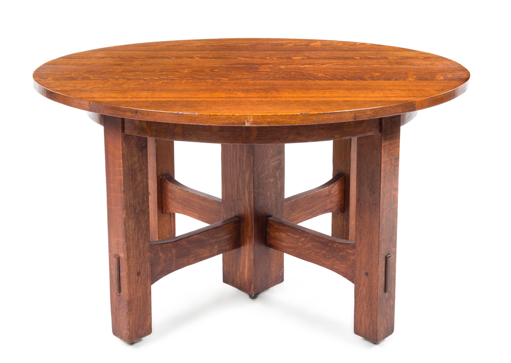 Gustav Stickley, (American, 1858-1942), an oak extension table, model no. 634, having a circular top expanding to oval, raised on squar