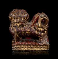 A Chinese Gilt and Red Painted Stone Fu Lion