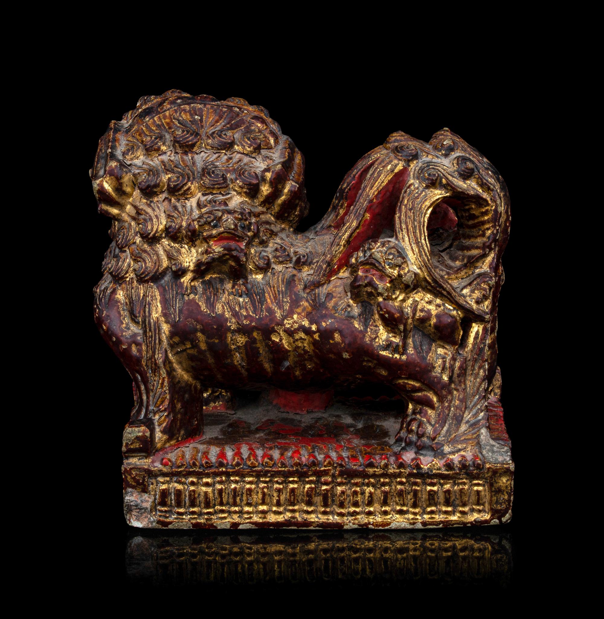 A Chinese Gilt and Red Painted Stone Fu Lion