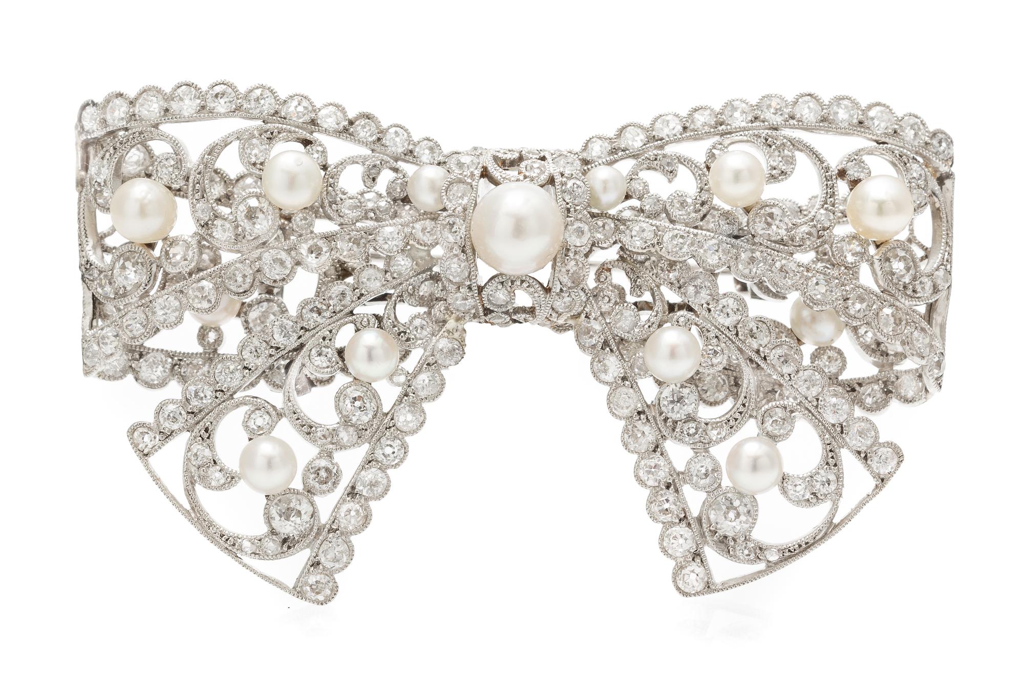 An Edwardian Platinum, Diamond and Pearl Bow Brooch, 23.00 dwts.