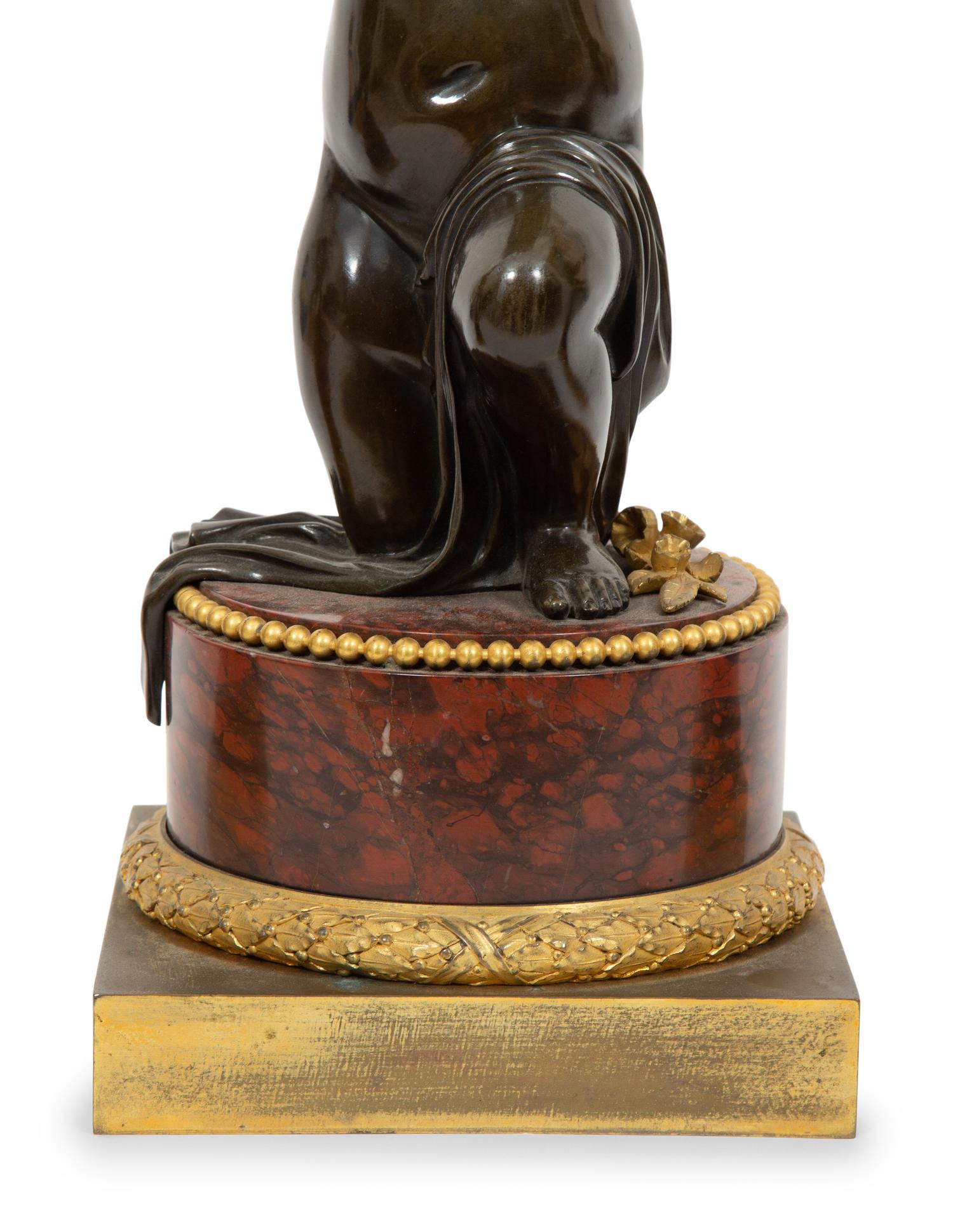 A French Gilt and Patinated Bronze and Rouge Marble Clock Garniture