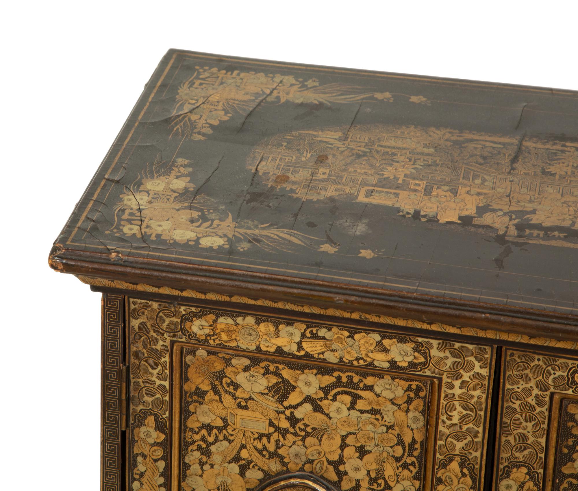 An English Black and Gilt Chinoiserie Decorated Cabinet with Interior Drawers
