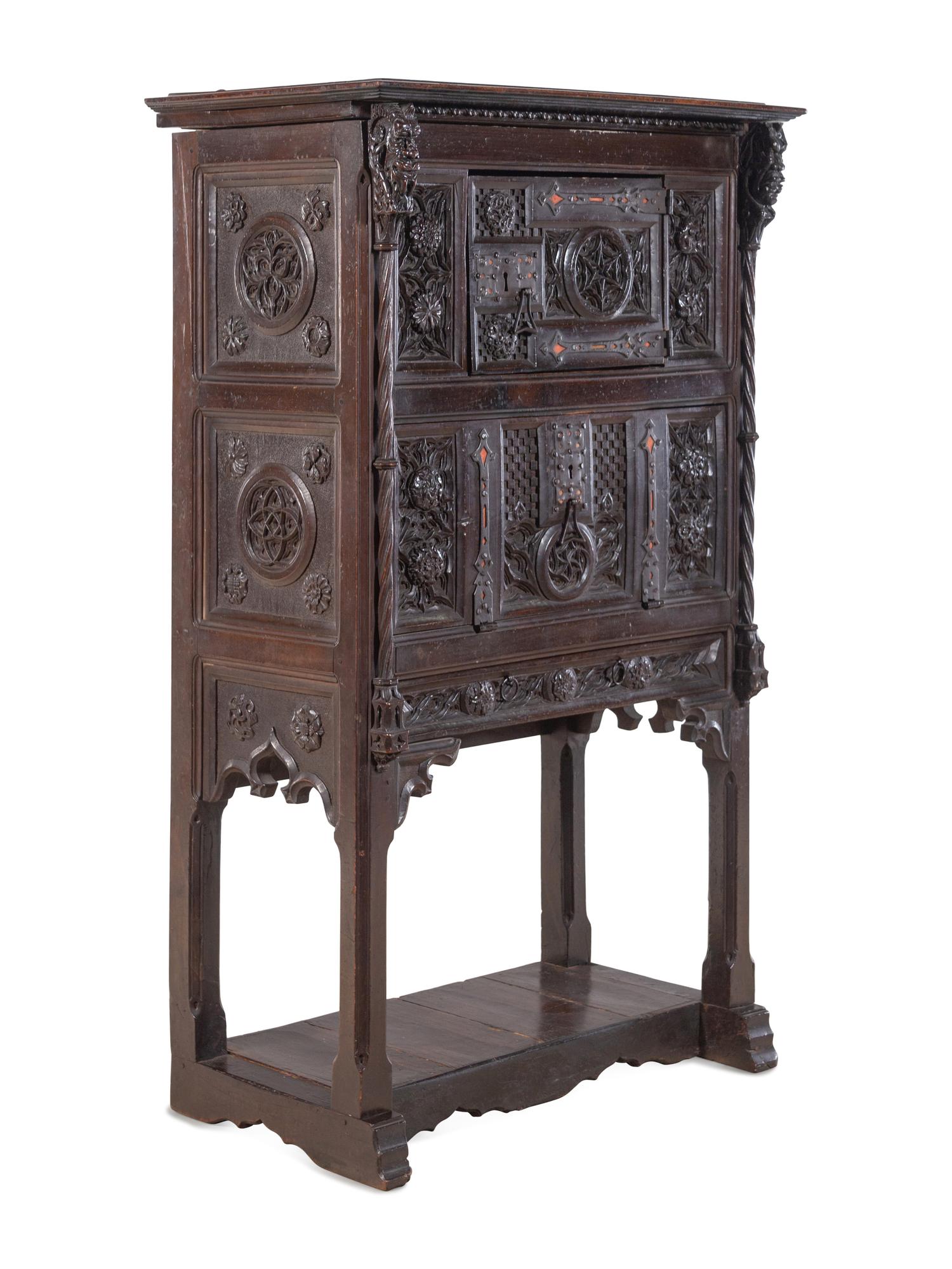 A Gothic Revival Carved Walnut Cabinet on Stand