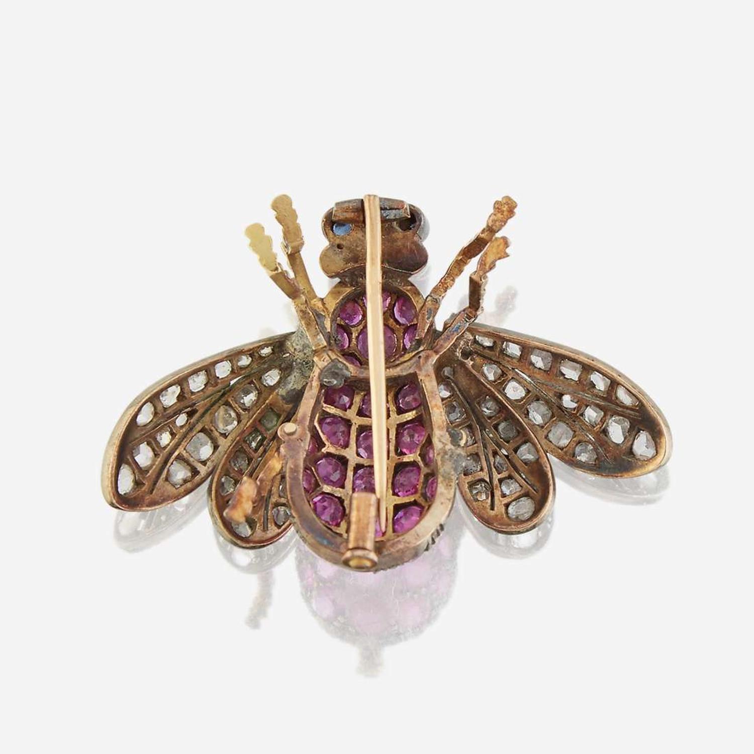 A silver topped gold, ruby, diamond, and sapphire brooch