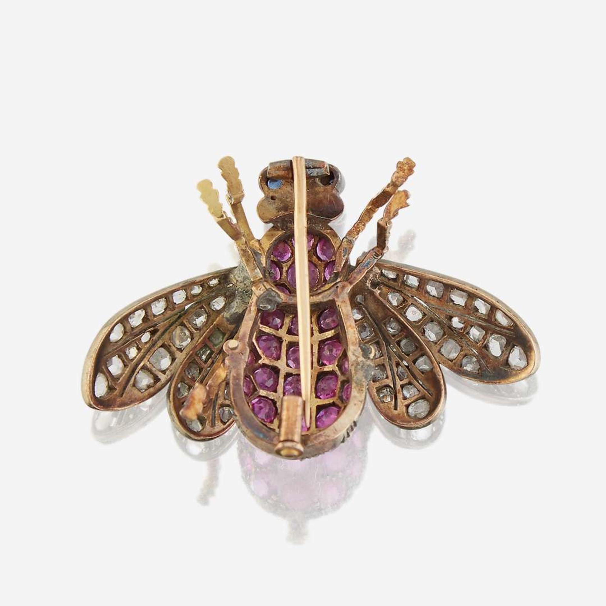 A silver topped gold, ruby, diamond, and sapphire brooch