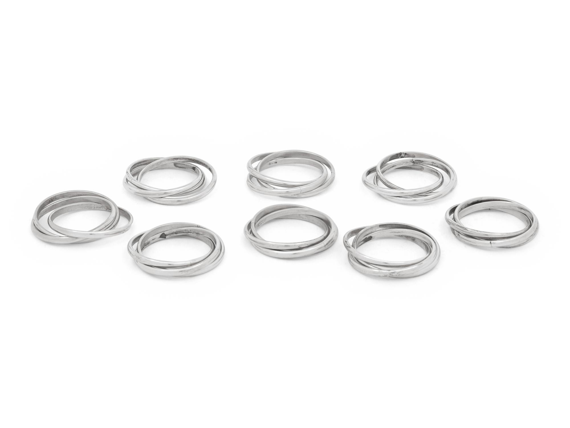 Two Cased Sets of Four Cartier Trinity Silver Napkin Rings
