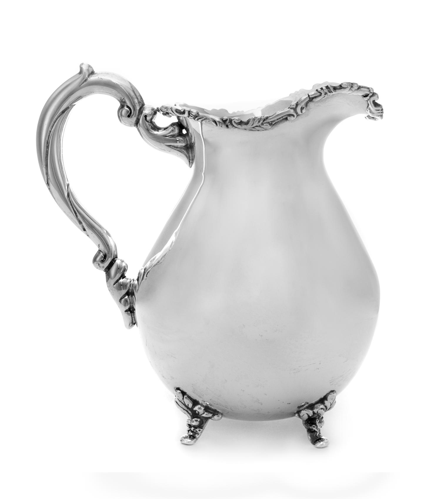 A Silver Water Pitcher, Maker's Mark JDB, having a baluster form body with an S-scroll and foliate decorated rim, raised on foliate fee