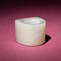 A Chinese Russet and White Jade 'Taotie and Chilong' Archer's Ring, 18th Century — 清中期 白玉留皮饕餮螭龍紋扳指
