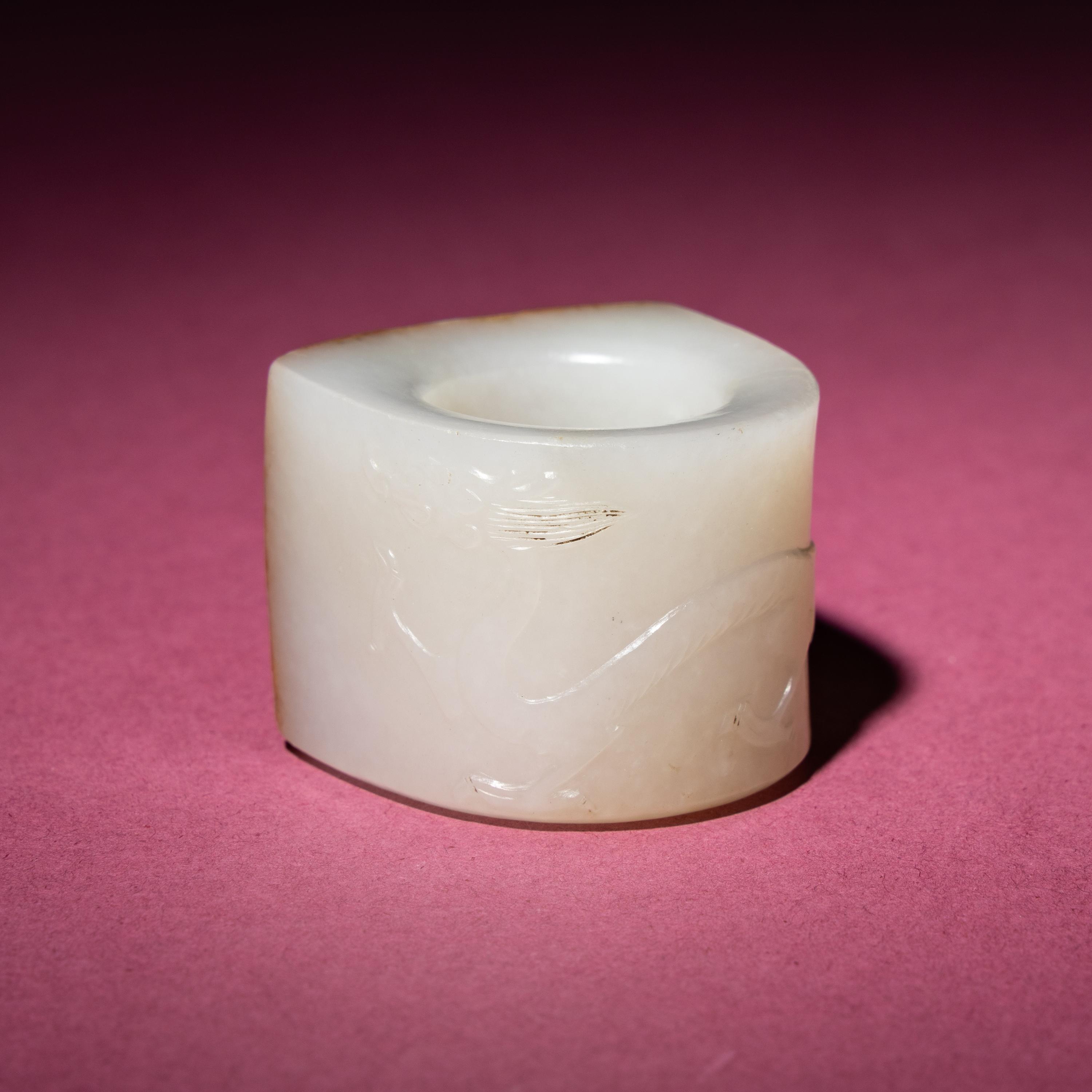 A Chinese Russet and White Jade 'Taotie and Chilong' Archer's Ring, 18th Century — 清中期 白玉留皮饕餮螭龍紋扳指