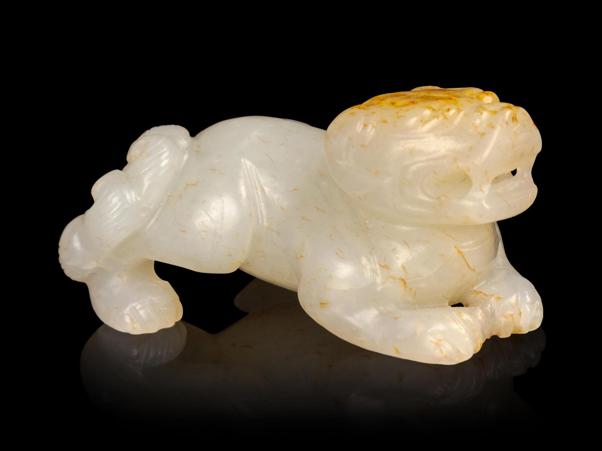 A Russet and White Jade Figure of a Recumbent Beast