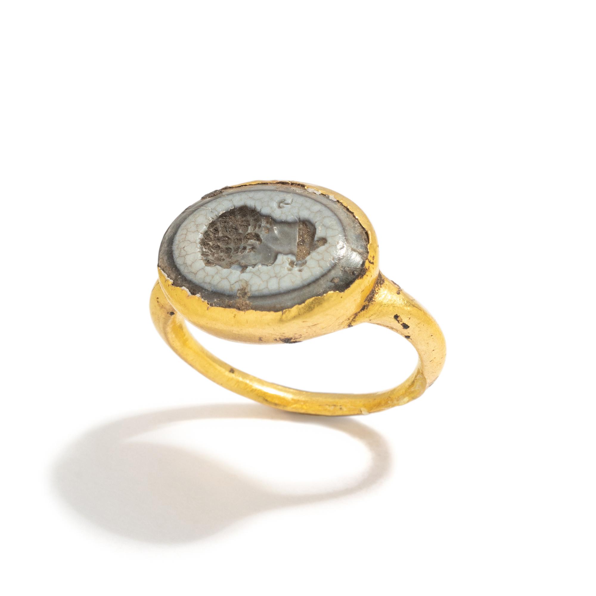 A Roman Gold and White Glass Finger Ring with a Male Portrait Head (Possibly a Young Hercules)