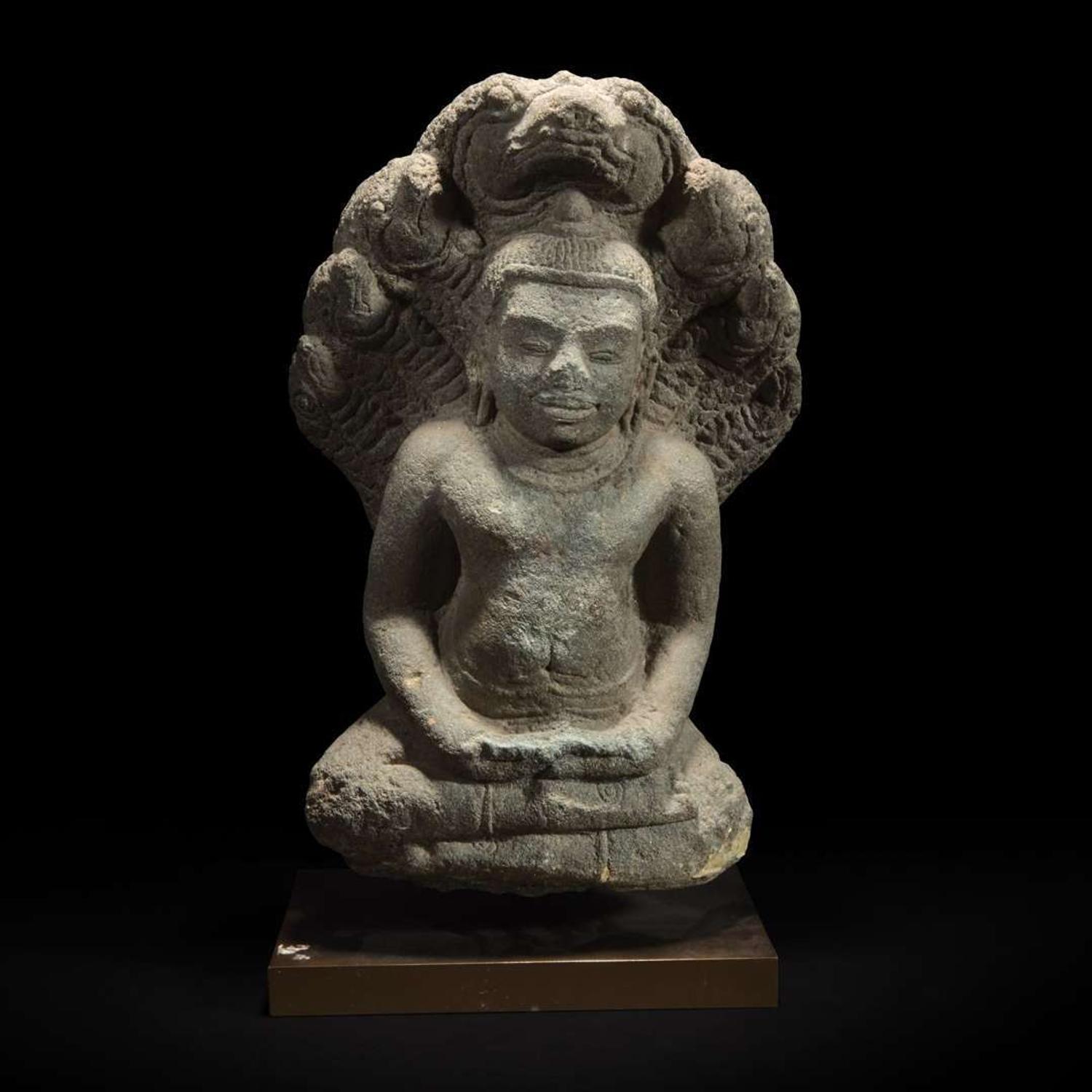 A Khmer style carved stone figure of Buddha seated under a cobra canopy 高棉风格石雕眼镜蛇冠冕佛首