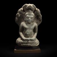 A Khmer style carved stone figure of Buddha seated under a cobra canopy 高棉风格石雕眼镜蛇冠冕佛首