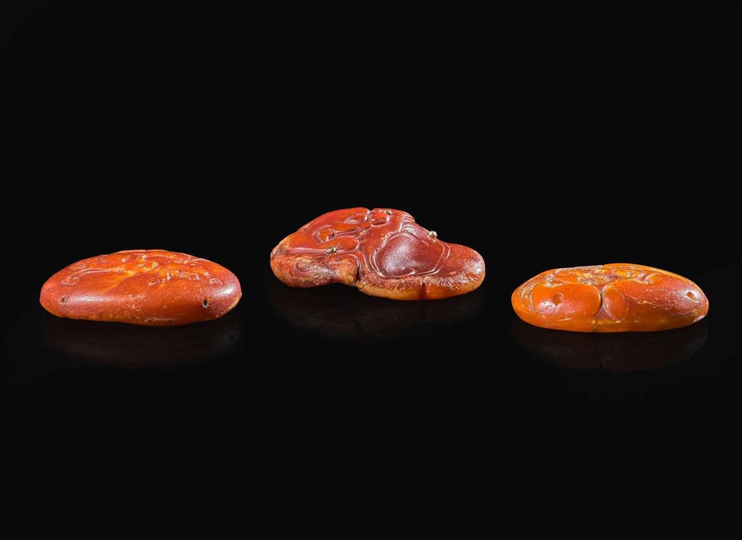 Three Chinese carved amber pendants, Ming to Qing dynasty 琥珀蜜蠟飾品三件 明或清