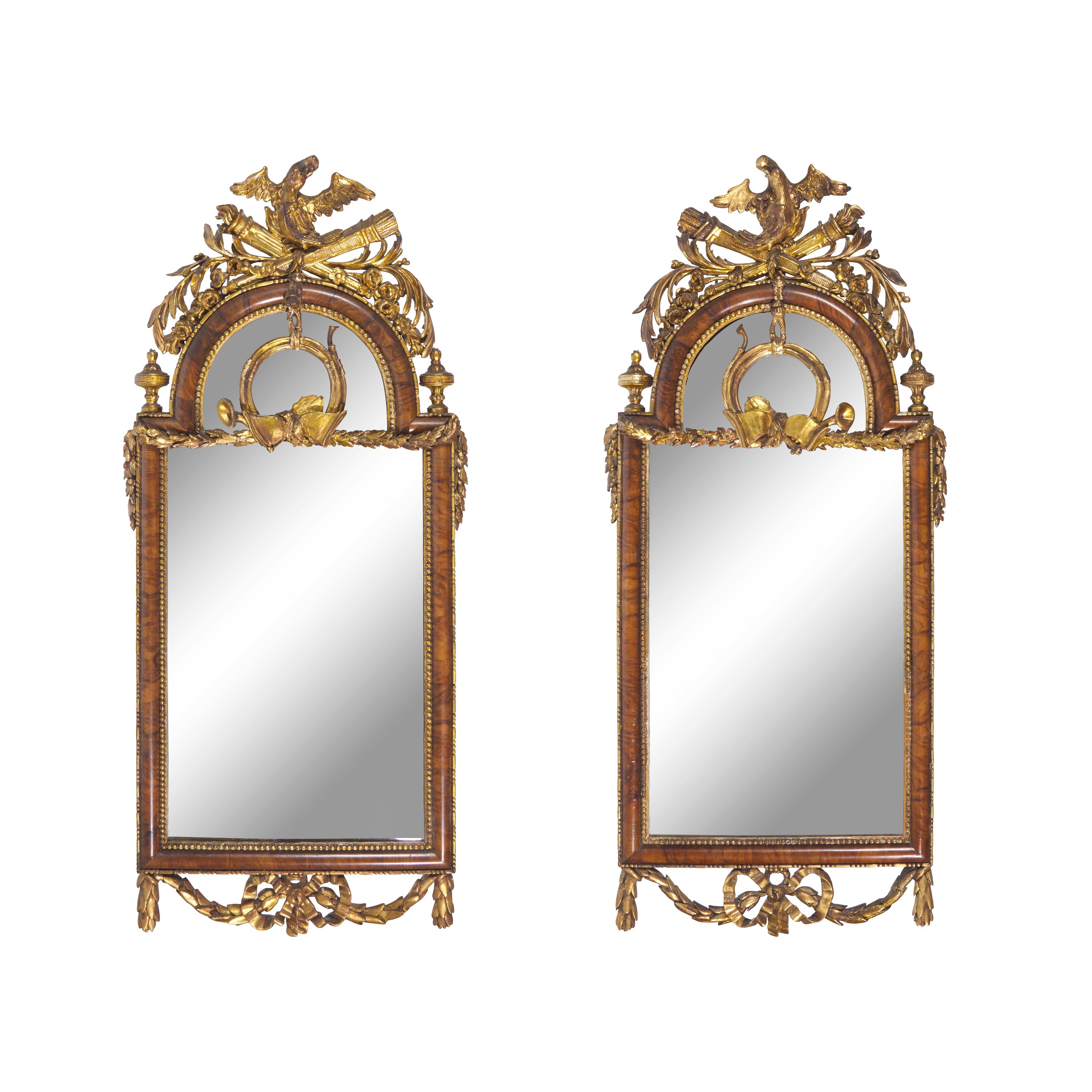 A Pair of Neoclassical Parcel Gilt Walnut Eagle-Decorated Looking Glasses