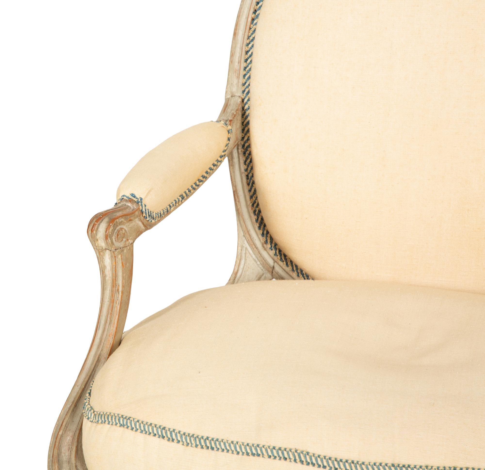 A Set of Four Louis XVI Grey-Painted and Parcel Gilt Fauteuils