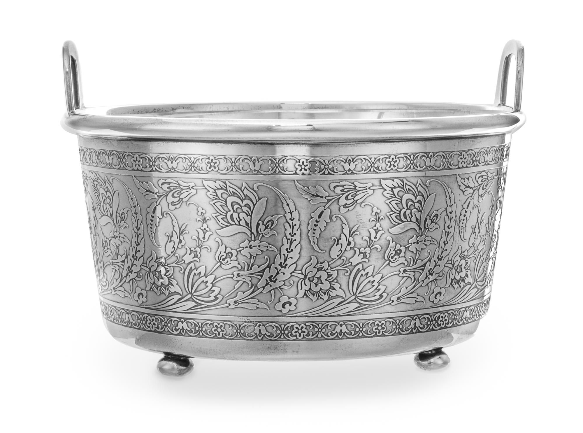 An American Silver Ice Bucket, Tiffany & Co., New York, NY, the handled body having a floral and foliate decorated band and a glass lin