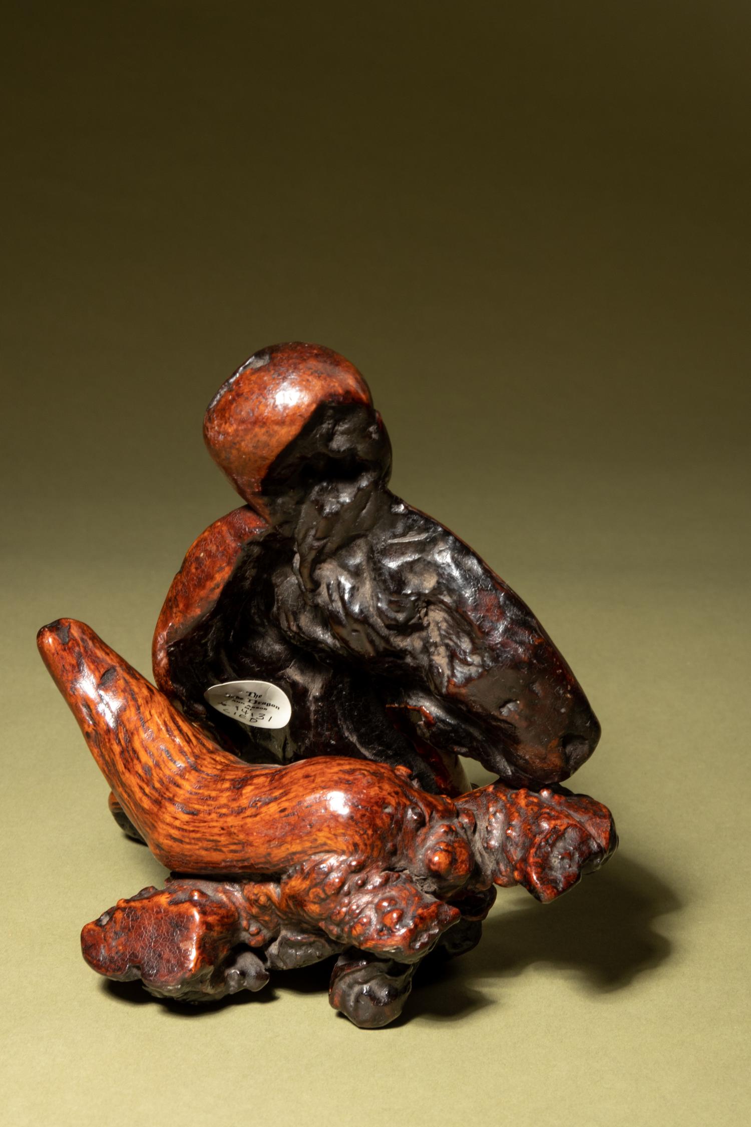 A Chinese Carved Root Figure of a Reclining Man and Stand