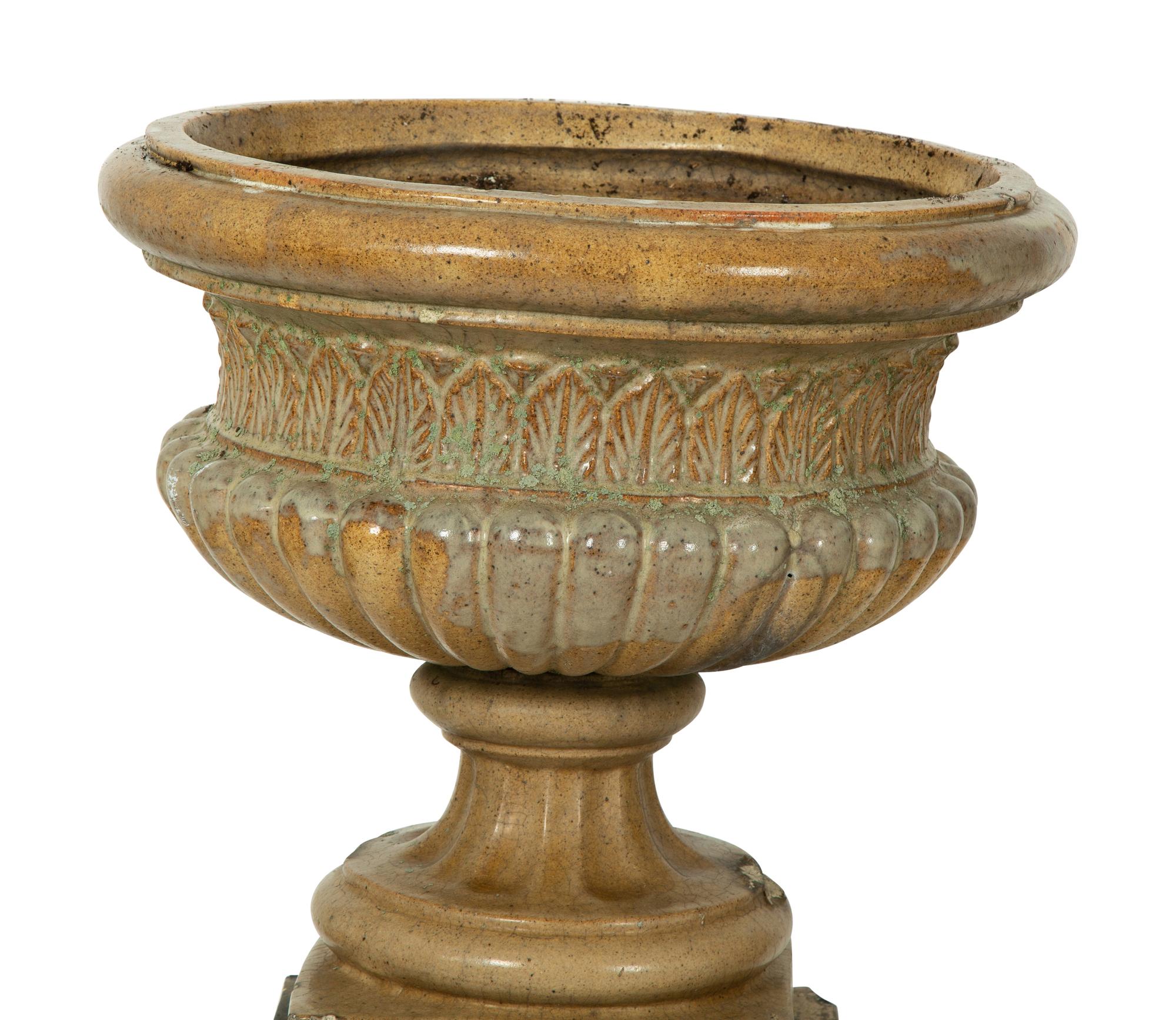 A Pair of Continental Ceramic Urns on Pedestals — EARLY 20TH CENTURY