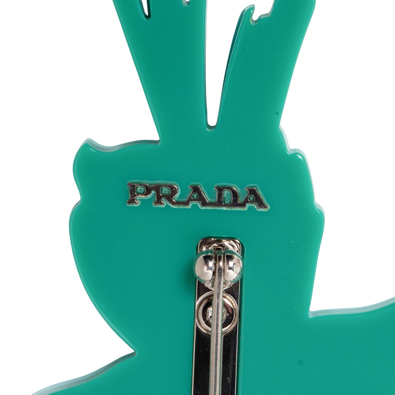 PRADA & MIU MIU, THREE BROOCHES & TWO PAIRS OF EAR CLIPS