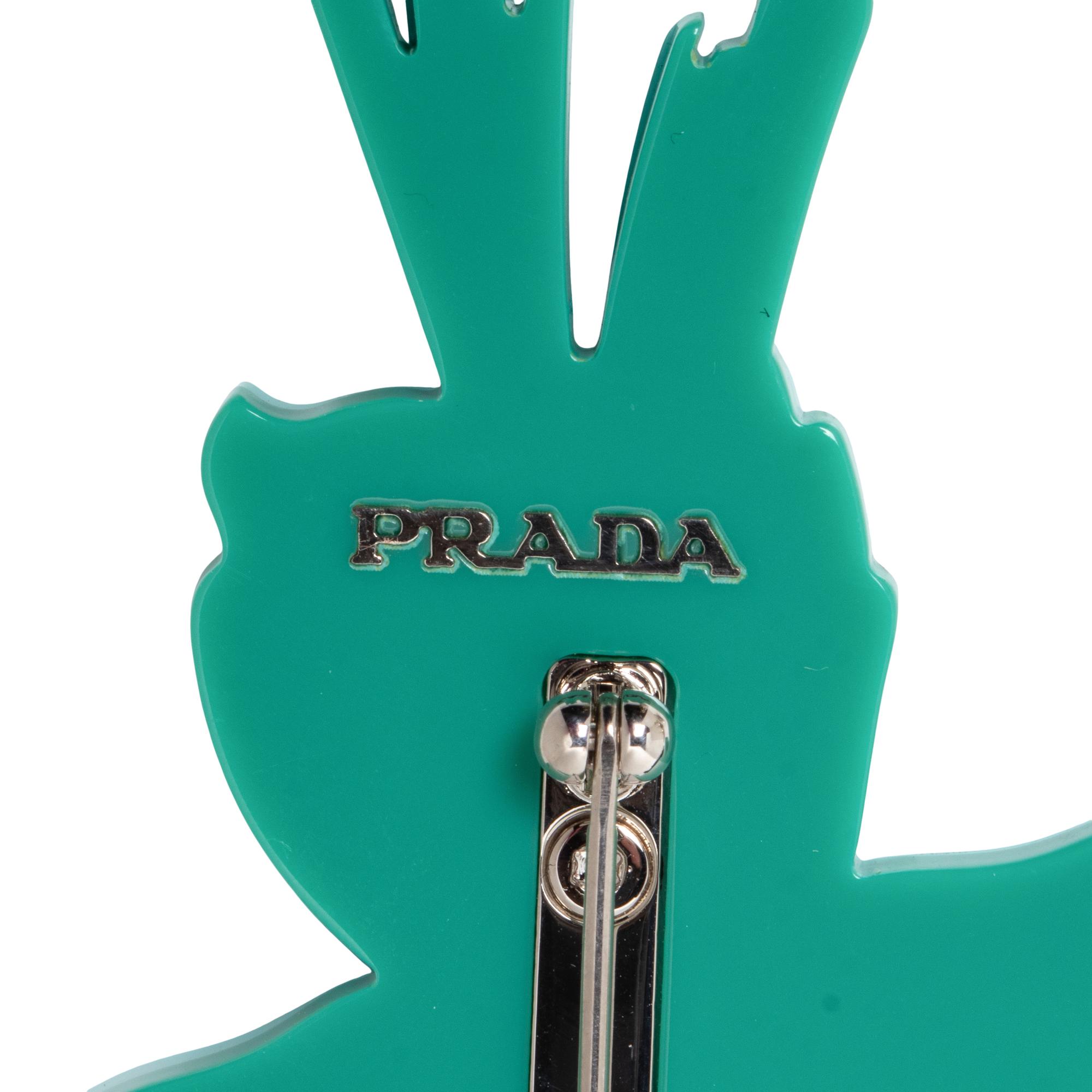 PRADA & MIU MIU, THREE BROOCHES & TWO PAIRS OF EAR CLIPS