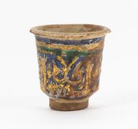 An Islamic Blue, Green and Iridescent Gold Glazed Pottery Cup Height 2 7/8 inches. — CIRCA 12TH CENTURY