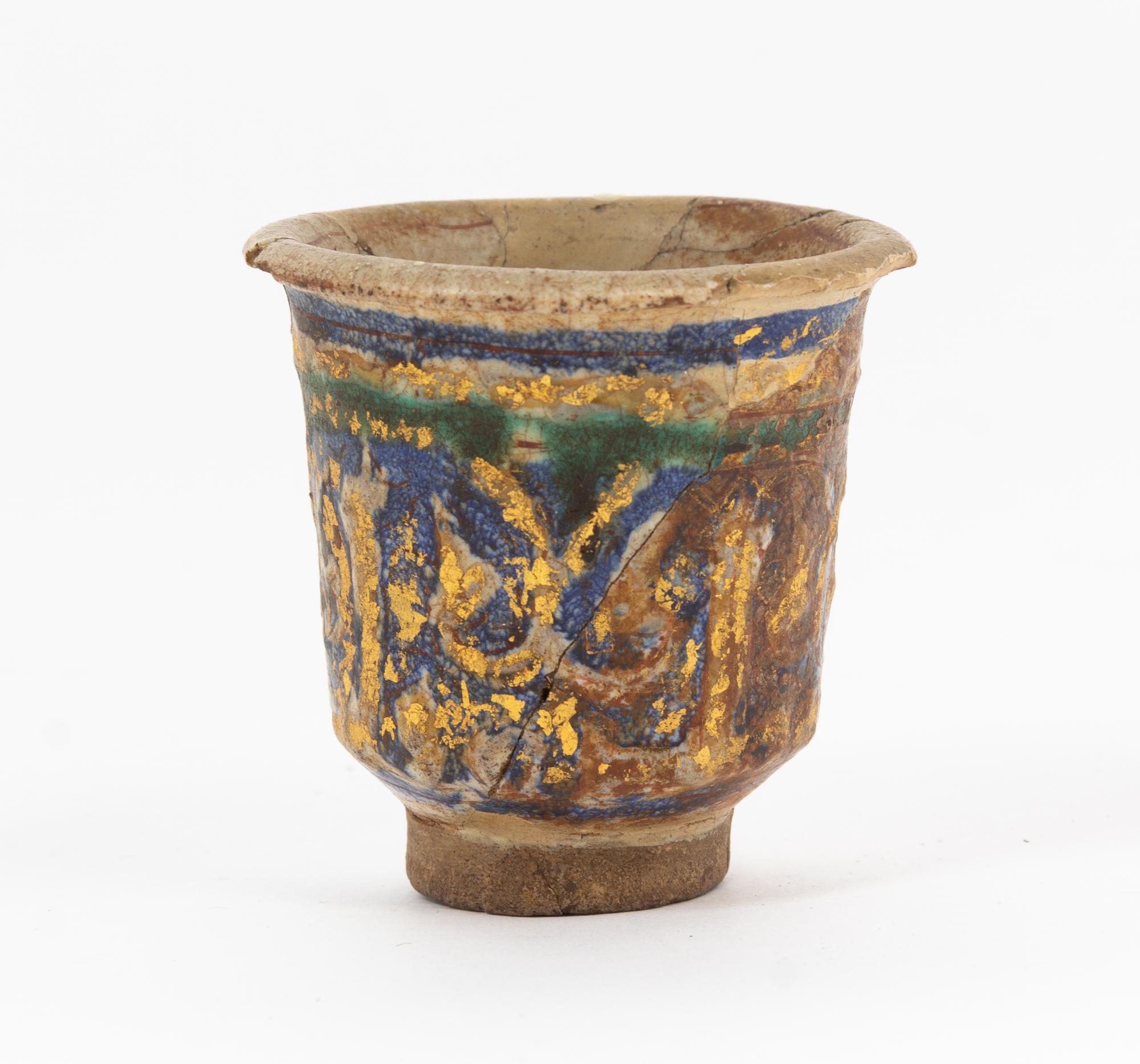 An Islamic Blue, Green and Iridescent Gold Glazed Pottery Cup Height 2 7/8 inches. — CIRCA 12TH CENTURY