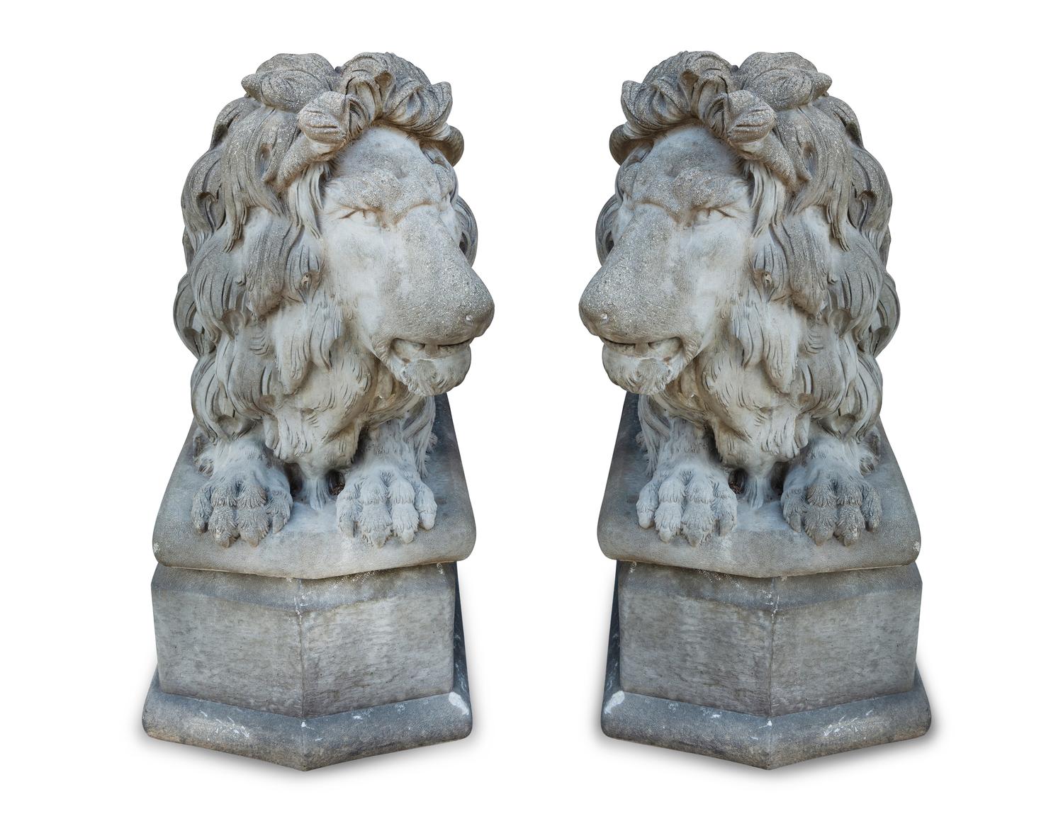 A Pair of Cast Stone Recumbent Lions on Pedestal Bases