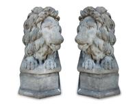 A Pair of Cast Stone Recumbent Lions on Pedestal Bases