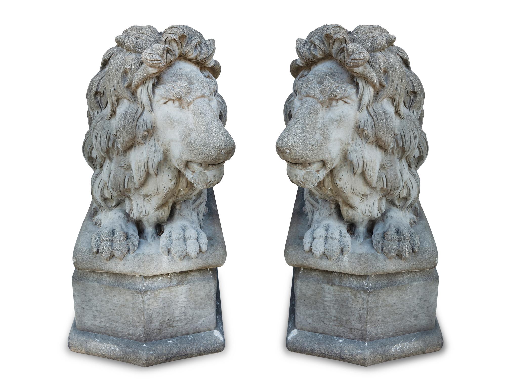 A Pair of Cast Stone Recumbent Lions on Pedestal Bases