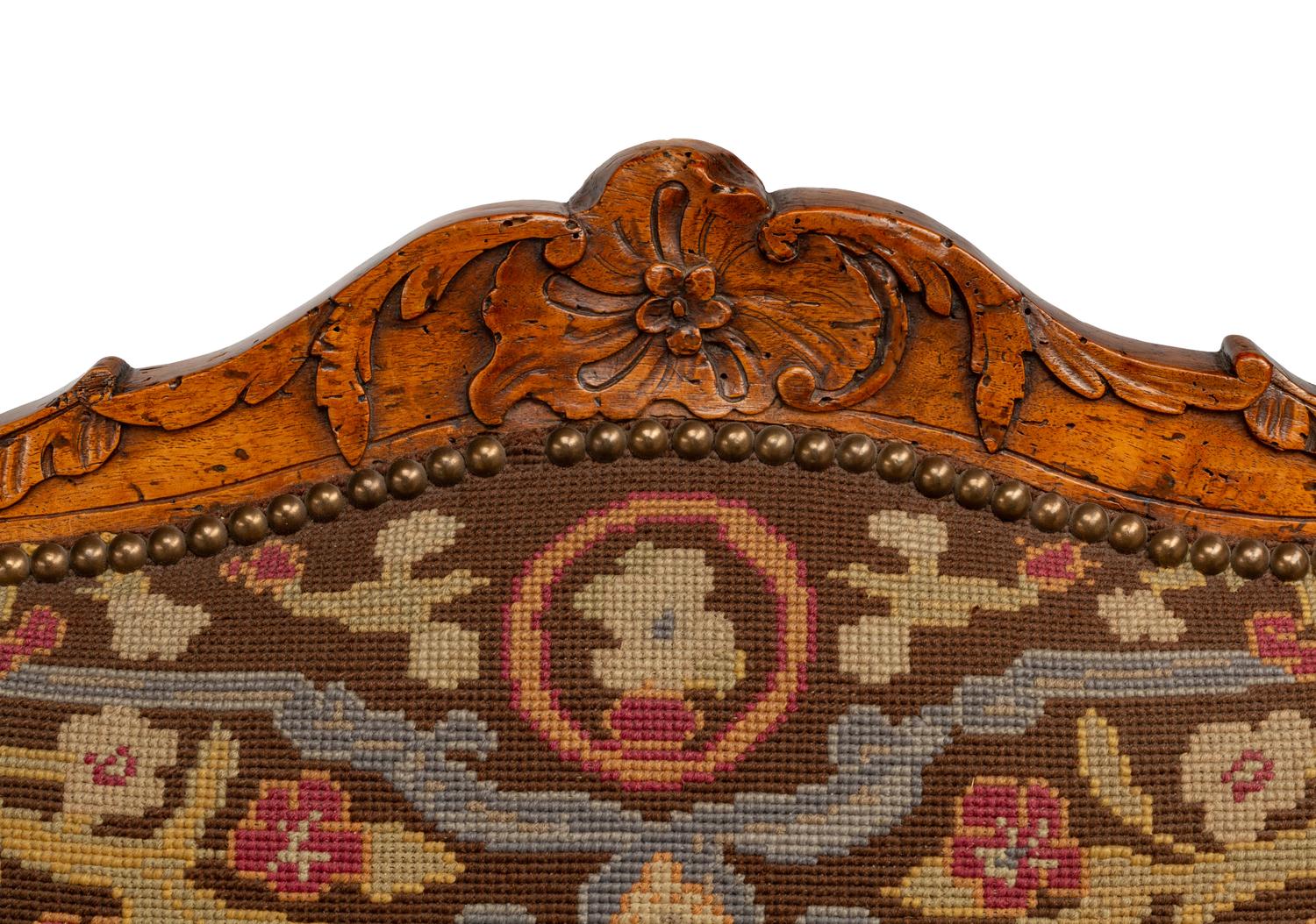 A Pair of Régence Walnut Needlepoint-Upholstered Fauteuils
