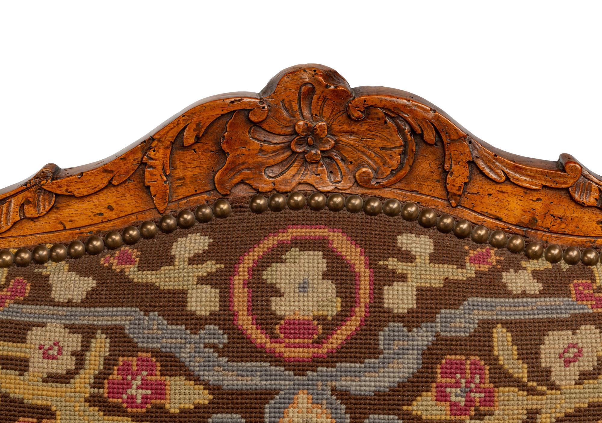 A Pair of Régence Walnut Needlepoint-Upholstered Fauteuils